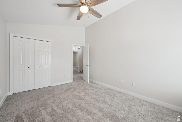 unfurnished bedroom featuring a closet, baseboards, carpet, and vaulted ceiling