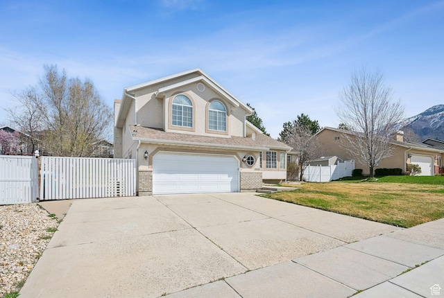 traditional-style home featuring concrete driveway, stucco siding, a front lawn, a garage, and fence