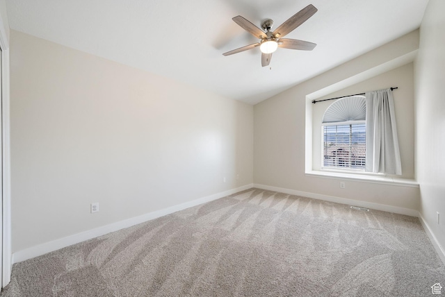 carpeted empty room with baseboards, vaulted ceiling, and ceiling fan