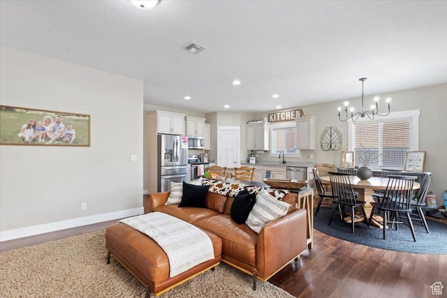 living area with dark wood-style flooring, baseboards, an inviting chandelier, recessed lighting, and visible vents
