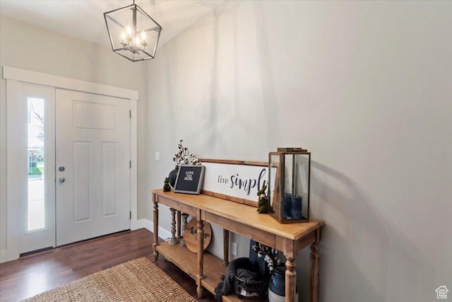 entryway with baseboards, an inviting chandelier, and wood finished floors