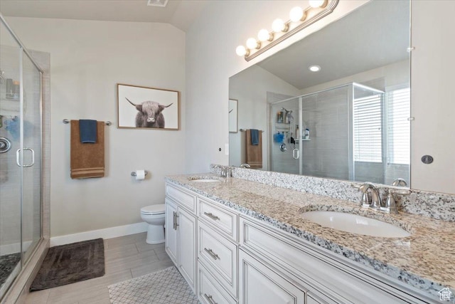 bathroom featuring toilet, a stall shower, a sink, and vaulted ceiling