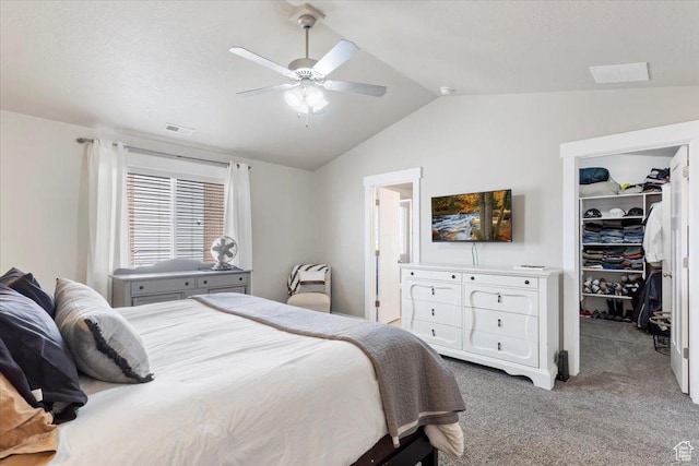 bedroom with a closet, a spacious closet, carpet floors, visible vents, and lofted ceiling
