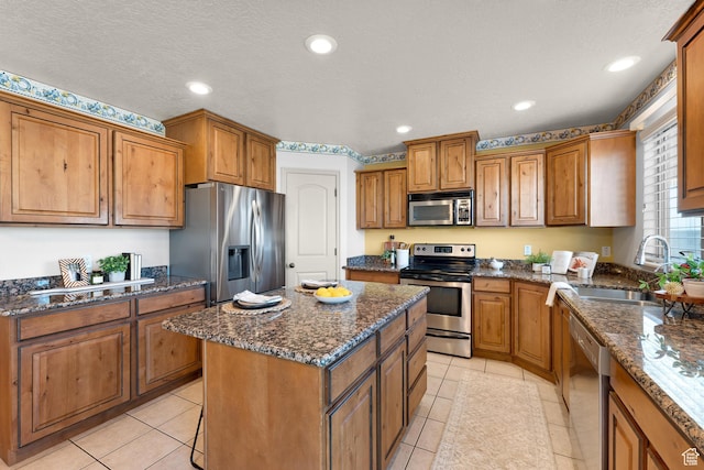 kitchen with a center island, brown cabinets, a sink, and stainless steel appliances
