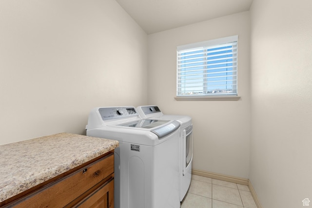 washroom featuring independent washer and dryer, laundry area, light tile patterned floors, and baseboards