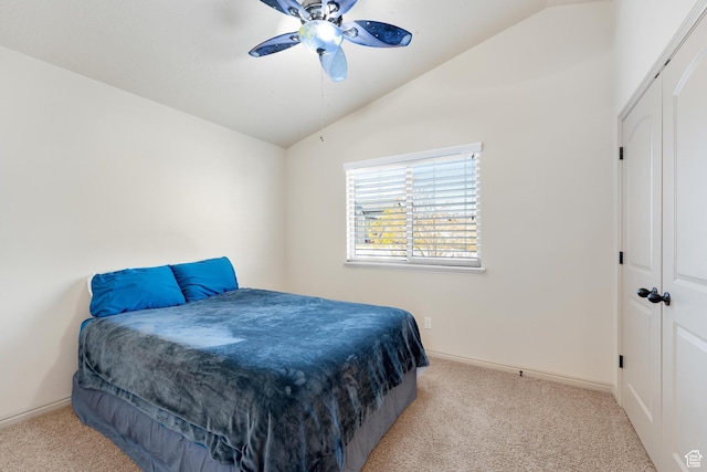 carpeted bedroom with a closet, baseboards, ceiling fan, and lofted ceiling