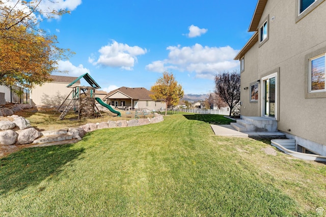 view of yard with fence and a playground