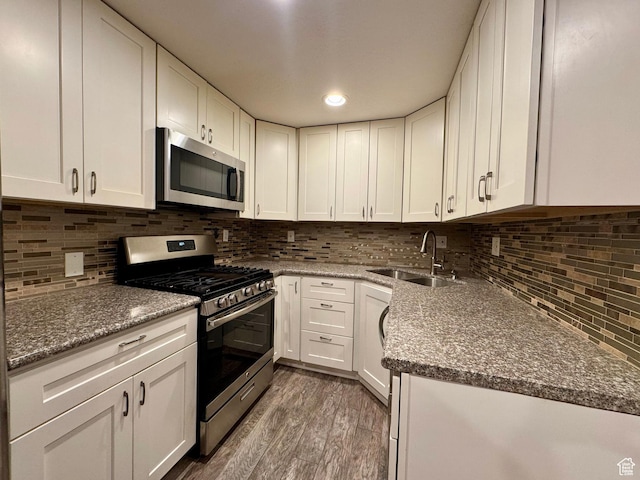 781 N Sherwood Dr, Layton, UT 84041 - kitchen with white cabinets, stone countertops, appliances with stainless steel finishes, wood finished floors, and a sink