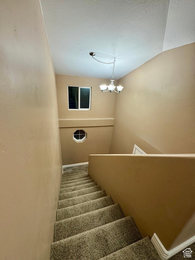 781 N Sherwood Dr, Layton, UT 84041 - stairway featuring a textured ceiling, a notable chandelier, and baseboards