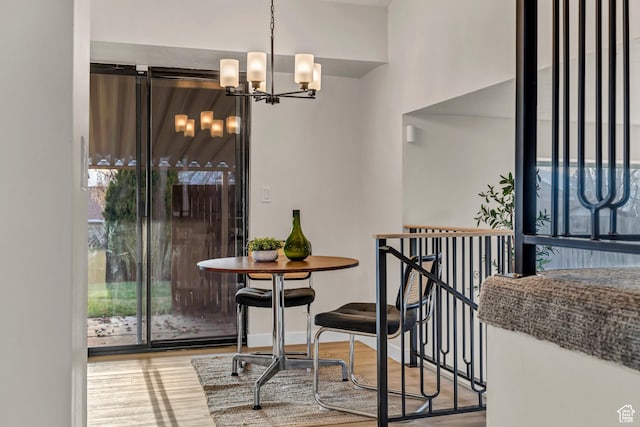 dining space featuring a chandelier, baseboards, and wood finished floors