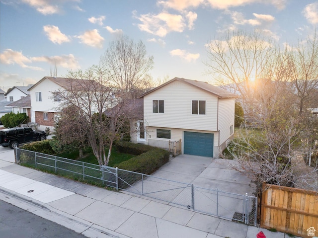 view of front of house featuring concrete driveway, a gate, an attached garage, and a fenced front yard