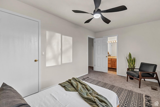 bedroom featuring ensuite bathroom, light colored carpet, a ceiling fan, visible vents, and baseboards