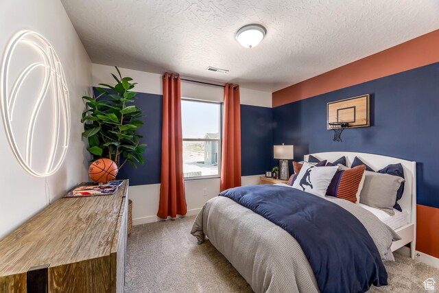 bedroom featuring a textured ceiling, visible vents, baseboards, and carpet