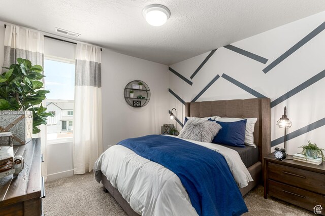 carpeted bedroom with visible vents and a textured ceiling