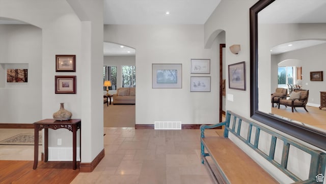 2847 W Amini Way S, Jordan, UT 84095 - hallway with visible vents, baseboards, arched walkways, recessed lighting, and stone tile floors