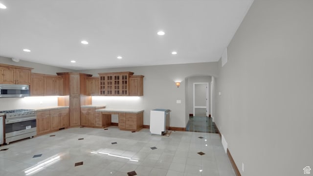 2847 W Amini Way S, Jordan, UT 84095 - kitchen with glass insert cabinets, baseboards, arched walkways, appliances with stainless steel finishes, and recessed lighting