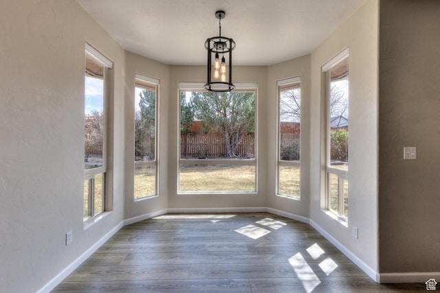 unfurnished dining area featuring baseboards and wood finished floors