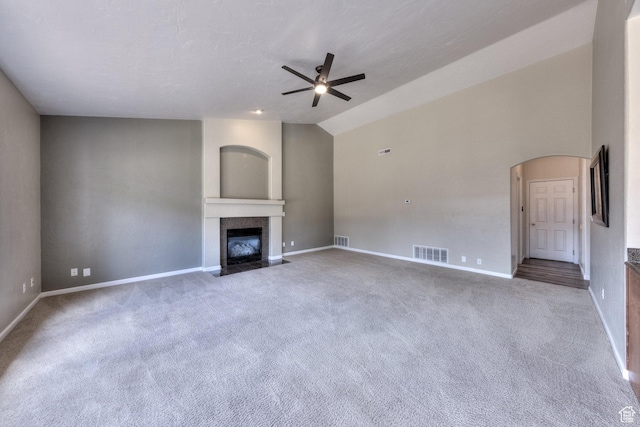 unfurnished living room featuring a fireplace with flush hearth, visible vents, carpet floors, and ceiling fan