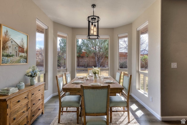 dining space featuring dark wood-type flooring and baseboards