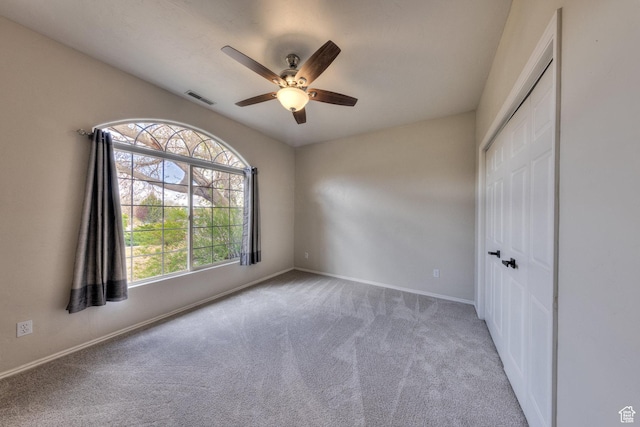 unfurnished bedroom featuring visible vents, baseboards, a closet, a ceiling fan, and carpet flooring