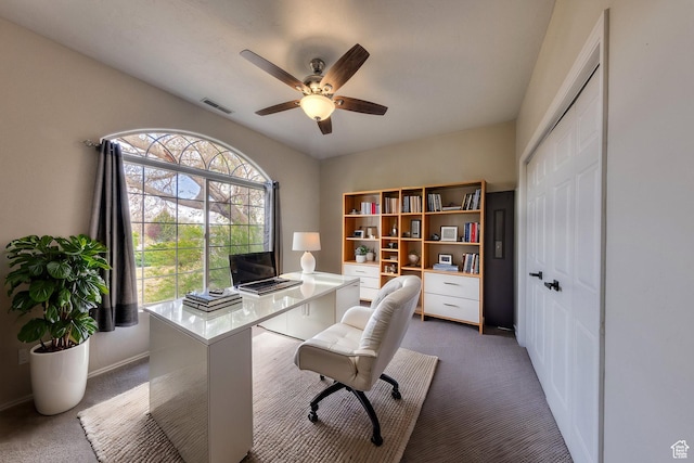 carpeted office space with visible vents and ceiling fan