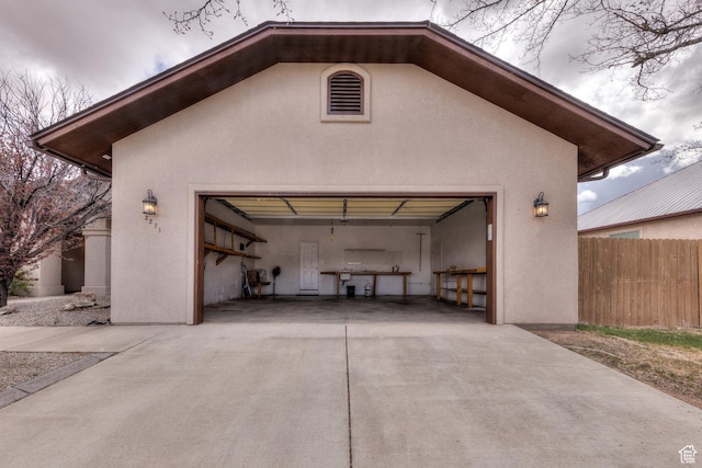 garage with driveway and fence