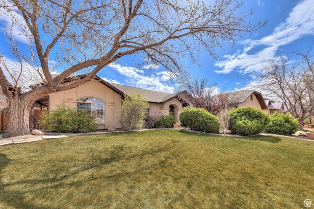 view of front of home with a front yard and stucco siding