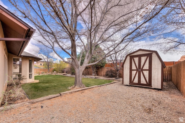 view of yard featuring an outbuilding, a fenced backyard, and a storage shed