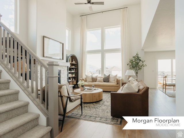 13678 S Langdon Dr Unit 2315, Riverton, UT 84096 - living area featuring stairway, a fireplace, ceiling fan, a towering ceiling, and wood finished floors