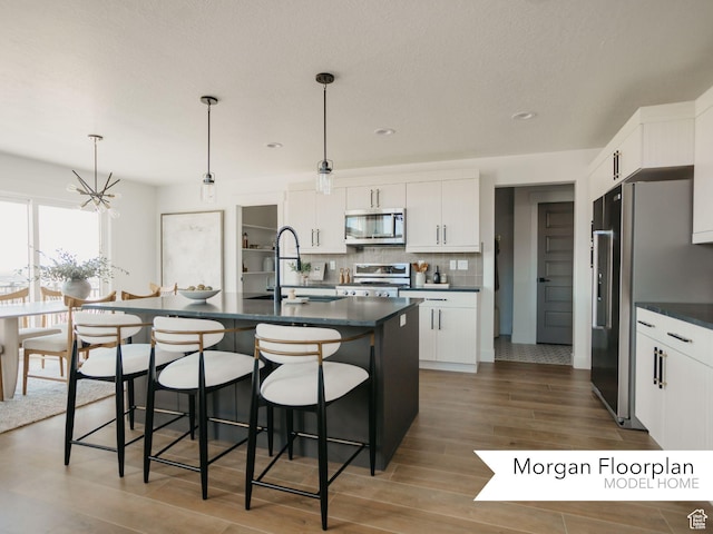 13678 S Langdon Dr Unit 2315, Riverton, UT 84096 - kitchen with appliances with stainless steel finishes, dark countertops, a breakfast bar area, and a sink