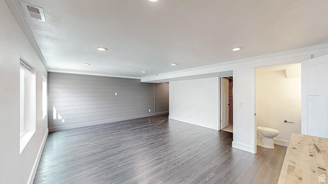 interior space featuring crown molding, dark wood-style flooring, baseboards, and visible vents