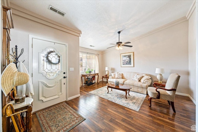 entryway with visible vents, ornamental molding, a ceiling fan, a textured ceiling, and dark wood-type flooring