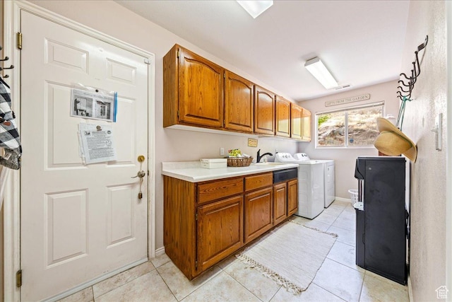 washroom featuring cabinet space, independent washer and dryer, light tile patterned flooring, and baseboards
