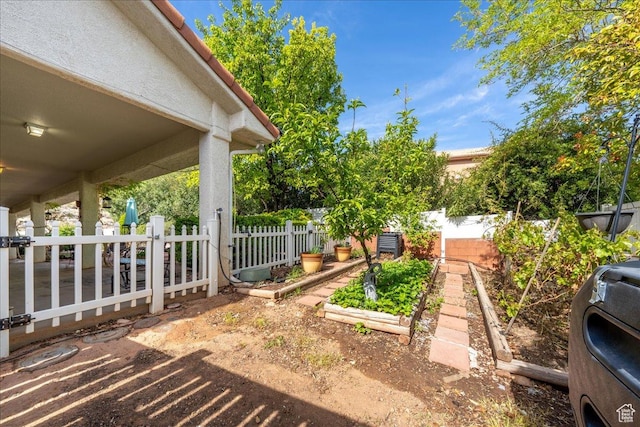 view of yard featuring fence and a vegetable garden