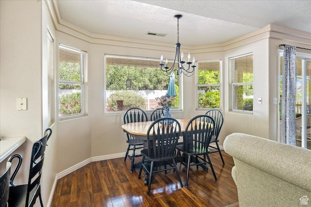 dining area featuring dark wood-style flooring, visible vents, a wealth of natural light, and an inviting chandelier