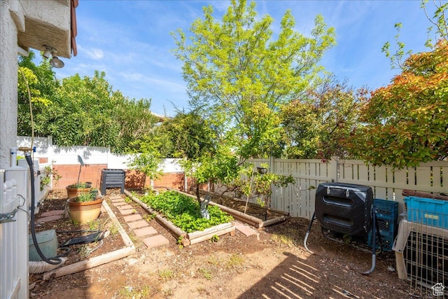 view of yard featuring fence and a vegetable garden