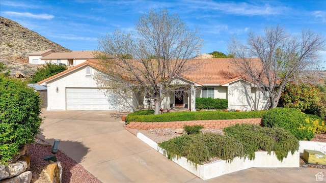 view of front of property featuring an attached garage, driveway, stucco siding, and a tile roof