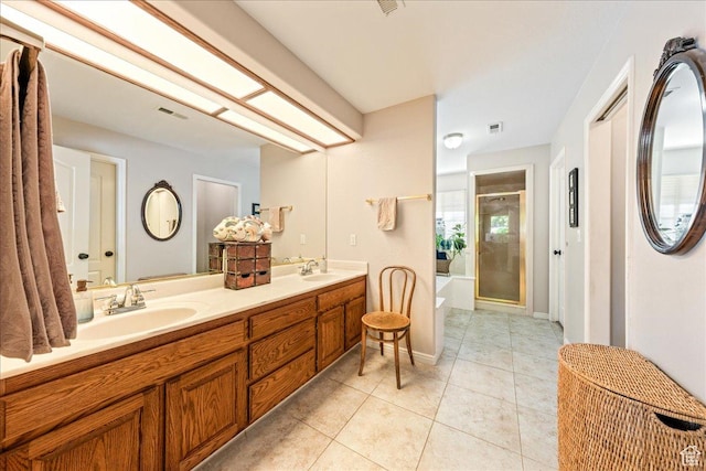 full bathroom featuring a stall shower, a garden tub, a sink, and tile patterned floors