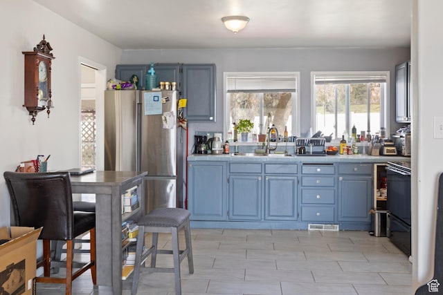 4622 S 375 E, Washington Terrace, UT 84405 - kitchen with blue cabinetry, freestanding refrigerator, a sink, and tile counters