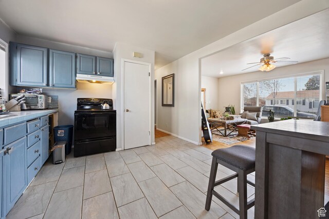 4622 S 375 E, Washington Terrace, UT 84405 - kitchen with ceiling fan, a kitchen breakfast bar, blue cabinetry, under cabinet range hood, and black range with electric stovetop