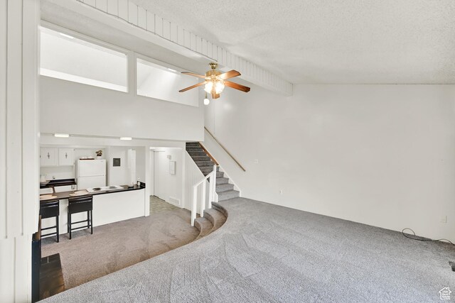 1298 Lorl Ln Unit 2, Ogden, UT 84404 - carpeted living area with a textured ceiling, high vaulted ceiling, ceiling fan, and stairs