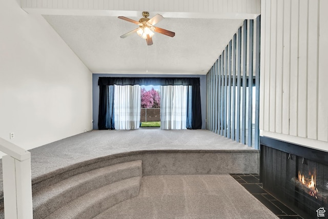 1298 Lorl Ln Unit 2, Ogden, UT 84404 - carpeted empty room featuring a fireplace with flush hearth, a textured ceiling, a ceiling fan, and vaulted ceiling