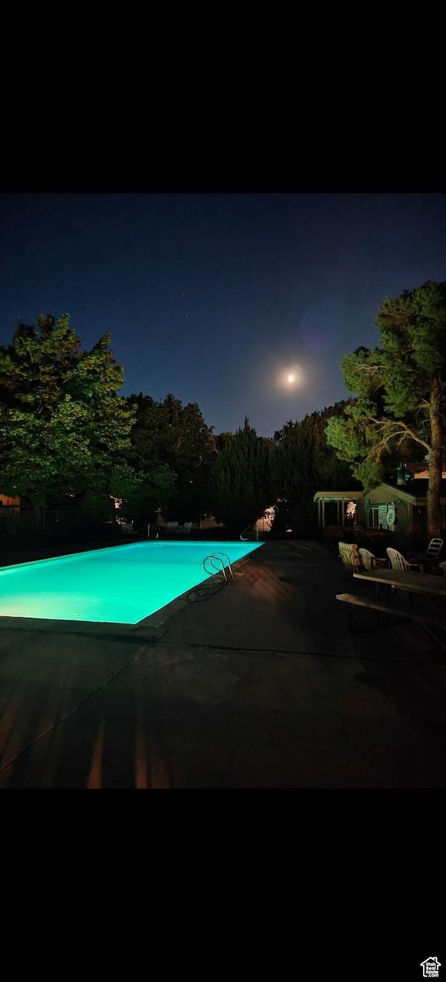1298 Lorl Ln Unit 2, Ogden, UT 84404 - pool at twilight featuring a patio and an outdoor pool