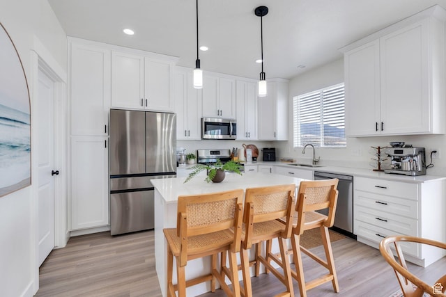 2888 E Carriage Hill Dr, Eagle Mountain, UT 84005 - kitchen featuring white cabinets, light wood finished floors, a sink, and appliances with stainless steel finishes