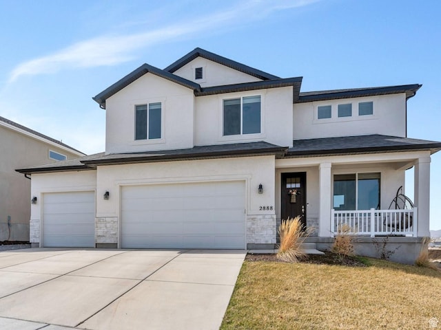 view of front facade with an attached garage, a porch, stone siding, stucco siding, and driveway