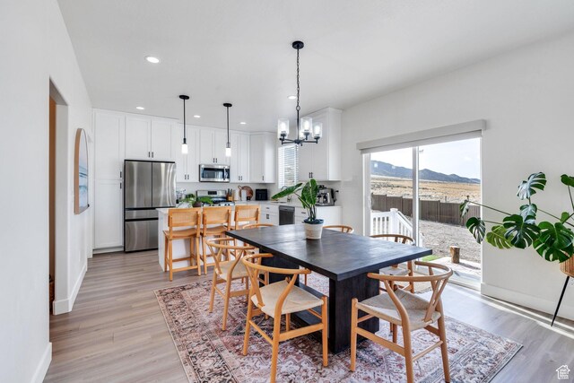 2888 E Carriage Hill Dr, Eagle Mountain, UT 84005 - dining area featuring baseboards, an inviting chandelier, a mountain view, recessed lighting, and light wood-style flooring