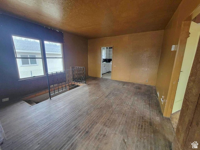 empty room featuring wood-type flooring and a textured ceiling