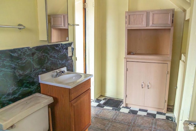 half bathroom with tile patterned floors, vanity, and toilet