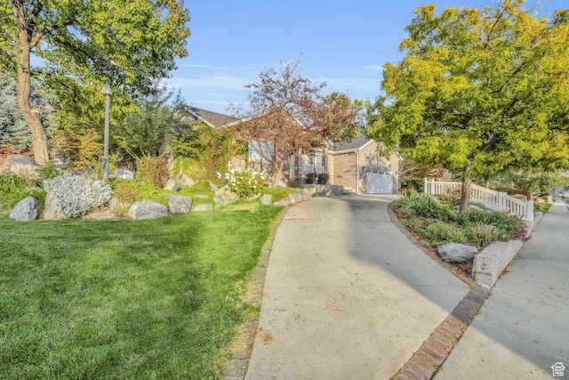 307 E 680 N, Lindon, UT 84042 - obstructed view of property featuring concrete driveway, an attached garage, and a front lawn