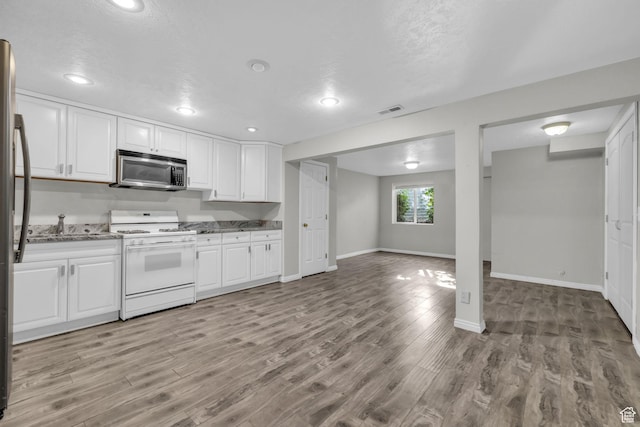 307 E 680 N, Lindon, UT 84042 - kitchen with visible vents, stainless steel microwave, white cabinetry, light wood-style flooring, and white gas range oven